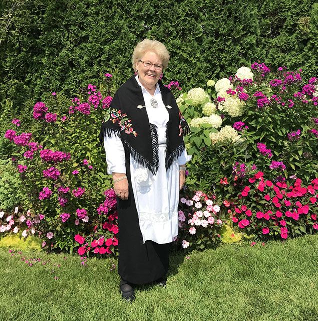 Lauraine Snelling in front of her flower gardens.